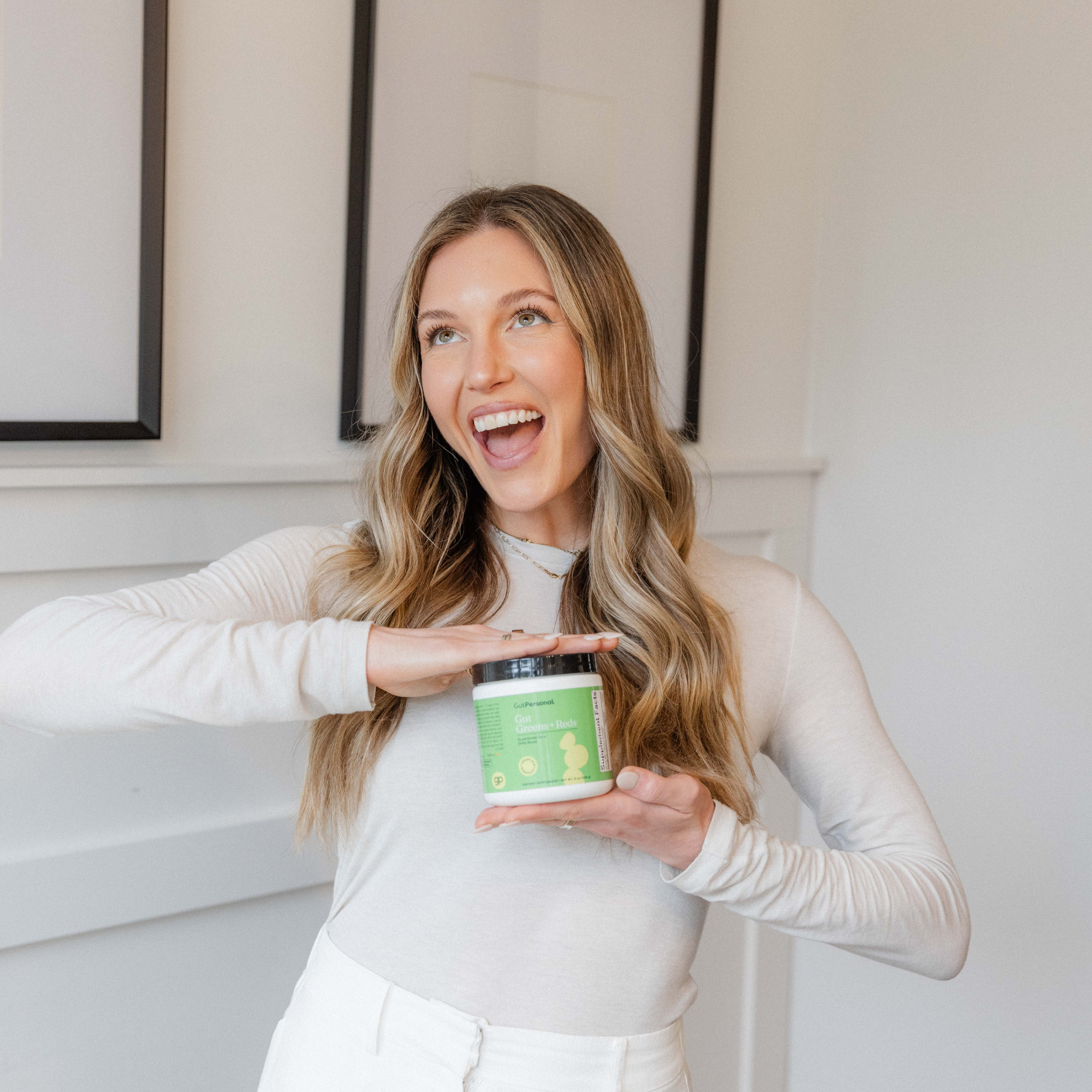 women holding gut greens + reds superfoods container